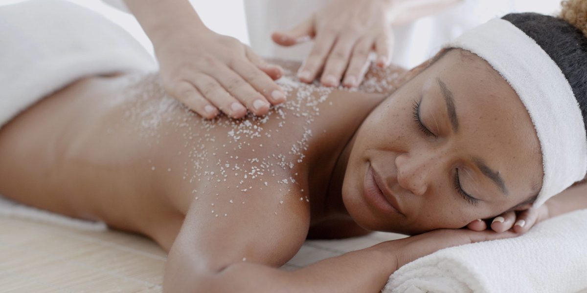 Female getting a salt scrub beauty treatment in the health spa